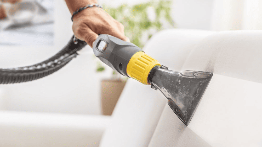 Επαγγελματικός βιολογικός καθαρισμός σαλονιού με ειδικό μηχάνημα ατμού σε λευκό καναπέ